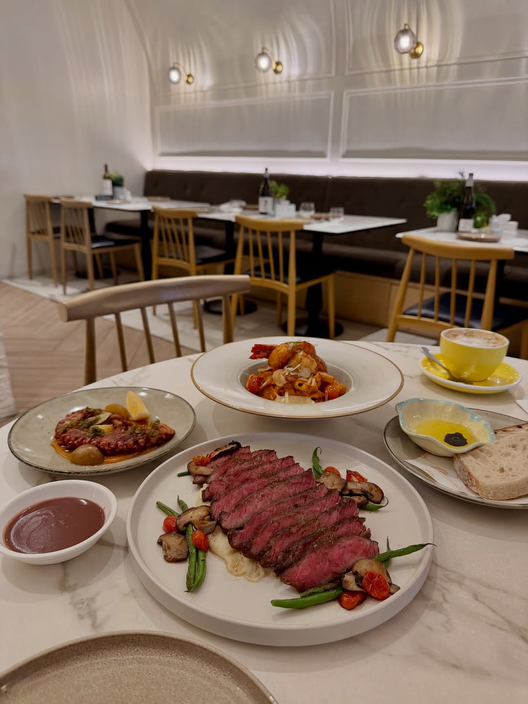 Sourdough Cafe Rockwell — table spread with steak, pasta and coffee